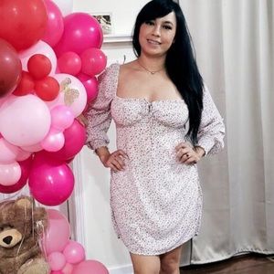 summer dress pink roses and green stems background of dress is off white.